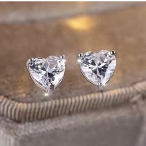 Elegant heart-shaped stud earrings in a shimmering silver tone.